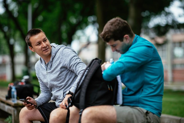 Zwei junge Männer unterhalten sich am Sportplatz
