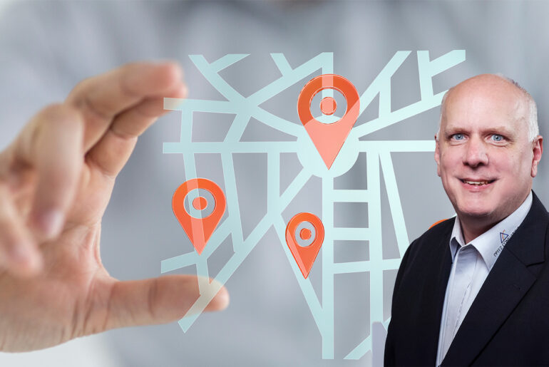 Oracle-Forms-Experte Gerd Volberg vor einer Navigationskarte