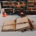 An Old Book and Candles on Wooden Table with Glass Bottles